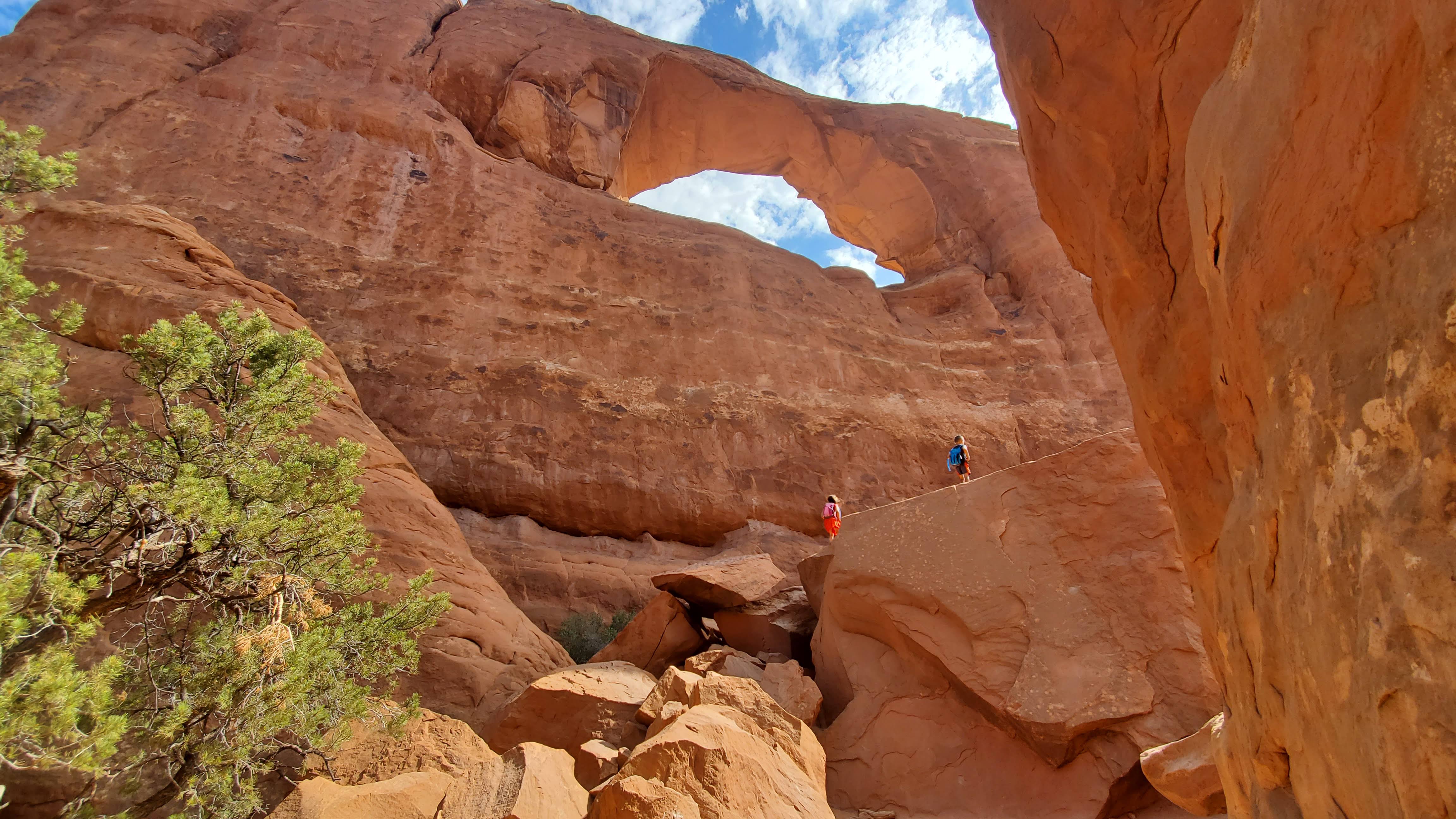 Image of the kids climbing up to an arch in Arches National Park.